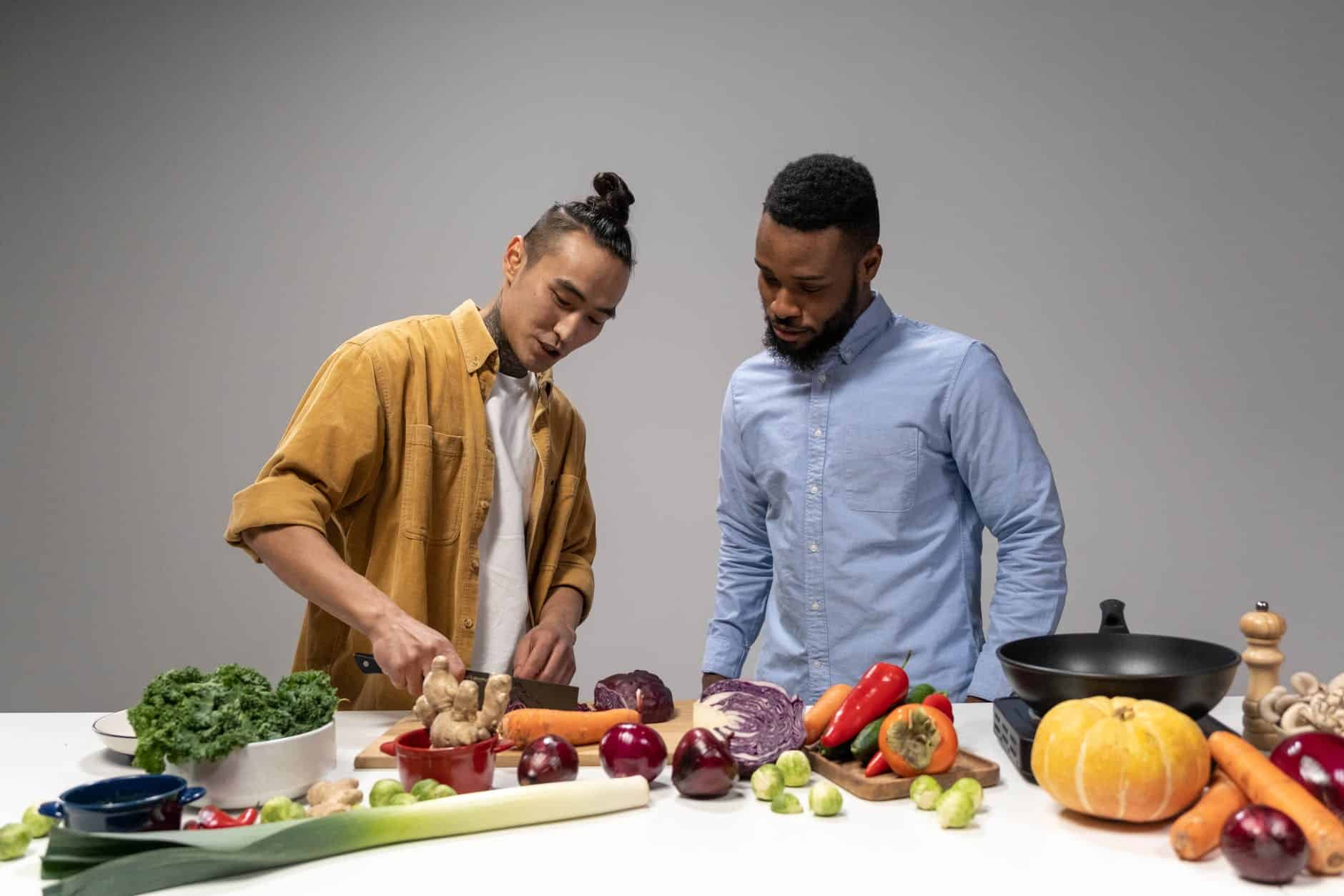 man in yellow jacket slicing vegetable